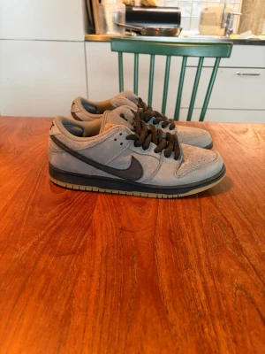 Nike Dunk sb Low grå/svarta sneakers - Säljer ett par gråa Nike dunk sb low i grå färg. Storlek 44. Knappt använda. Inköpta på supreme butiken i london på höstlovet.