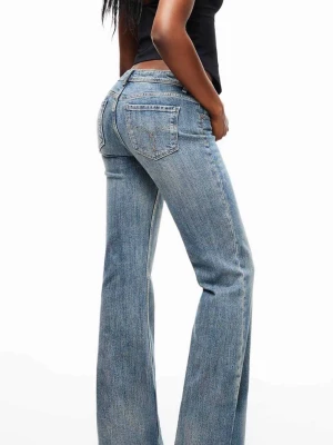 Blå bootcut jeans med hög midja - Snygga blå bootcut jeans med hög midja och klassisk femficksdesign. Jeansen har en ljus tvätt och raka ben som går ut något nedtill för en retroinspirerad look. Tillverkade i denim med en skön passform.