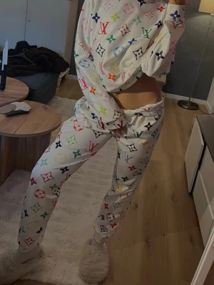 Färgglatt  loungewear-set - Säljer ett vitt loungewear-set . Setet består av en långärmad tröja och matchande byxor i mjukt material, perfekt för att chilla hemma. Oversized passform för extra komfort. Står ingen storlek men gissar på S.