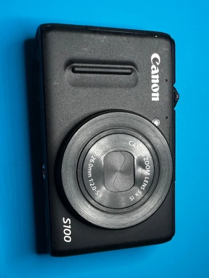 Canon PowerShot S100 digitalkamera - Säljer en svart Canon PowerShot S100 digitalkamera med inbyggd GPS och bildstabilisering. Kameran har ett kompakt format, rundade kanter och ett objektiv med 5x optisk zoom (24-120mm, f/2.0-5.9). Perfekt för dig som vill ha en smidig kamera med många funktioner. (Batteri saknas)