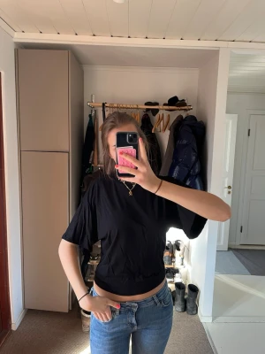 Svart loose-fit t-shirt - En svart t-shirt med loose-fit passform, sitter åt mer i midjan och har trekvarts ärmar. 