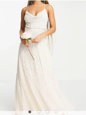 Ljusrosa långklänning med paljetter och öppen rygg - Säljer min otroligt fina ljusrosa balklänning 🌸 Tunna axelband som korsar ryggen, öppen rygg. Banden går att anpassa. Massa paljetter som glittrar fint i solen ✨ Bara använd 1 gång. Köpt på asos för 1700kr. Storlek 34/XS. Färgen skiftar i rosa/beige med vita paljetter