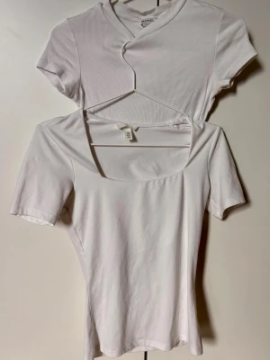 Två vita toppar från Monki och H&M - Säljer två vita toppar: en ribbad kortärmad topp från Monki med rund hals (strl S) och en enkel vit topp från H&M med fyrkantig ringning och korta ärmar (strl Xs) Båda är i mjuk bomull 🤍 (100 kr för båda)