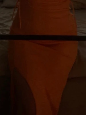 Orange omlottklänning med slits - Snygg orange klänning med omlott-design och hög slits framtill. Klänningen har knyt i midjan och figurnära passform, perfekt för dig som vill sticka ut. Passar dig som gillar trendiga och färgstarka plagg.