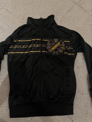 Svart AIK ziptröja med emblem - Säljer en svart ziptröja från AIK med klubbens stora broderat emblem från 515 jag säljer och byter den kom med bud 