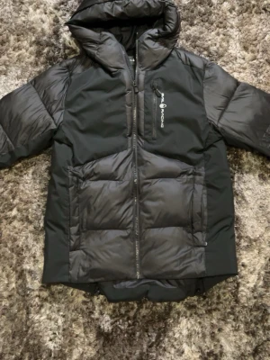 Sail Racing jacka - Svart jacka från Sail Racing. Köpt för 2800kr och använd endast 3 gånger och är i mycket bra skick, nästan som ny. Inga skador, fläckar eller slitage. Jackan är varm, skön att ha på sig och sitter bra. Kan gå ner i pris vid snabb affär och mer bilder finns om det behövs