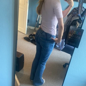 Blå bootcut jeans från Vero Moda - Snygga blå bootcut jeans från Vero Moda i klassisk denim. Modellen har låg midja och utsvängda ben, vilket ger en retro och trendig vibe. Perfekta för dig som gillar en avslappnad men ändå stilren look.