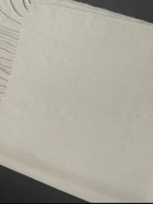 Beige mjuk halsduk med fransar - En stilren beige halsduk i mjukt tyg med klassiska fransar i ena änden. Perfekt för att addera en clean och enkel touch till din outfit. Materialet känns lent och passar bra till lager på lager-stil.