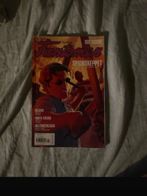Fantomen Spionskeppet serietidning - Säljer en serietidning från Fantomen med titeln Spionskeppet. Omslaget har en färgstark illustration i rött, orange och blått med actiontema. Innehåller 100 sidor och flera berättelser som Heloise, Hanta-häxan och Halloweenligan.