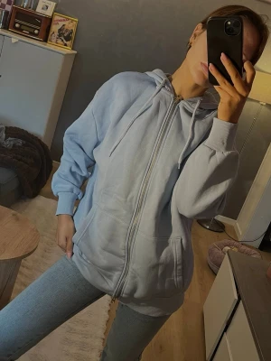 Ljusblå oversize zip hoodie med luva - Säljer en ljusblå hoodie med dragkedja framtill. Modellen är oversize. Aldrig använd. Från nakd storlek 36. 