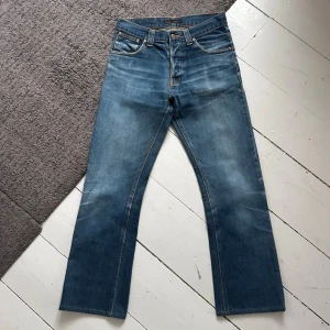 Mörkblåa Nudie Regular Alf Dry Grey Cast Jeans - Blåa Nudie jeans med en riktigt nice passform, lite bootcut. | W29 L34. | Riktigt fint skick, inga defekter alls. | Midja: 36-38.5cm, Längd: 96cm. | Pris ej hugget i sten, skriv vid minsta fundering. 