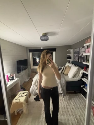 Ljusbeige stickad tröja öppen rygg  - Säljer en ljusbeige omlott topp med korta ärmar och öppen rygg. Toppen har en croppad passform och knytband bak. Perfekt för dig som gillar trendiga och stilrena plagg.