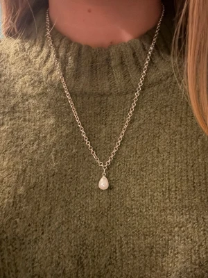 Silverhalsband med pärlhänge - Säljer ett halsband i silverfärg med ett droppformat pärlhänge. Rostfritt stål