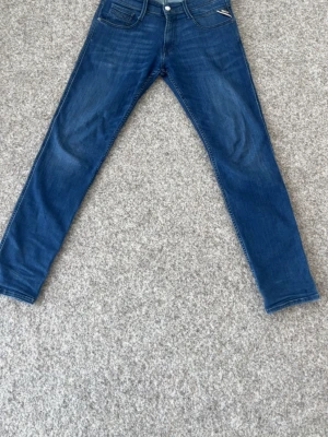 Blå skinny jeans från Replay - Säljer ett par blå skinny jeans från Replay med klassisk femficksmodell och normalhög midja. Jeansen har en snygg tvätt med lätt slitning och är tillverkade i stretchigt denim för skön passform. Byxorna är i modell anbass 30-32. Nypris: 1500 Mitt pris: 399