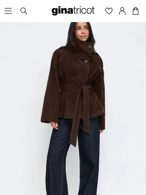 Mörkbrun trenchcoat i mocka från Gina Tricot - Funderar på att sälja denna trenchcoat/kappa i mocka i storlek. Köpt på Gina Tricot, har aldrig användt den och lappen sitter kvar. Tveka inte att höra av dig om du undrar något eller önskar fler bilder!