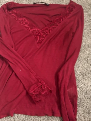 Vinröd långärmad topp med spets - Vinröd långärmad topp med v-ringning. Tunt men varmt material, den töjer inte ut sig som andra tröjor kan göra💗från bikbok men liknar intimisimis tröja väldigt mycke 