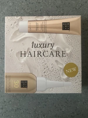 Rituals Luxury Haircare Set - Lyxigt hårvårdskit från Rituals med en spegelglansmask och ett detox schampokoncentrat. Förpackningen är elegant i guld och vitt, och produkterna innehåller bland annat rosa lera och äppelvinäger för extra vård och glans.