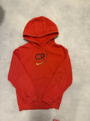 Nike CR7 Hoodie Str 137-147cm - Lillebrorsan fick nya CR7 kläder av mamma, men eftersom att han är lite kräsen ville han inte ha något av det. Denna är knappast använd, använd ca 2 gånger där han blev tvingad att ha på sig det. Sedan dess har bara legat i skåpet. Pris kan diskuteras! 