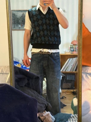 Stickad väst  - Mörkblå / grå / svart stickad väst. Storlek M. Fint skick. 