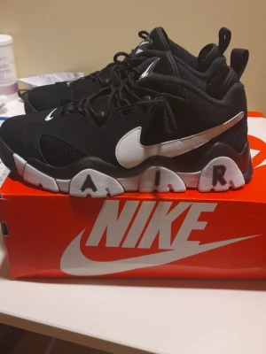 Nike Air Barrage Low svart/vit - Nike Air Barrage Low sneakers i svart med vita detaljer och tydlig AIR-text på sulan. Skorna har en chunky design, meshpaneler och klassisk Nike Swoosh på sidan och tån. Perfekta för dig som gillar sportig och trendig stil.