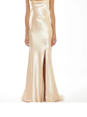 Champagnefärgad långklänning i satin - Elegant långklänning i skimrande champagnefärgad satin med slits framtill, öppen rygg och tunna axelband som knyts i nacken. Strl S skulle jag säga. Är 163cm ungefär och den sitter som på bilden på mig, men skulle absolut också passa flera cm längre. Inga defekter, använt en gång. Nypris 1400 kr. Skriv gärna om frågor uppstår, positiv till förhandling!