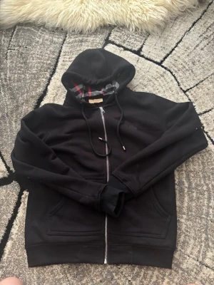 Burberry ziphoodie svart - Hej! Säljer en burberry ziphoodie med rött mönster. Vid frågor hör av er 