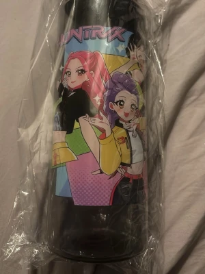 Svart vattenflaska med kpop  - Cool svart vattenflaska med färgglatt anime-inspirerat tryck av tecknade karaktärer och texten 'HUNTRX' på framsidan. Flaskan är i plast och har ett praktiskt lock. Perfekt att ta med till skolan, gymmet eller på utflykten.