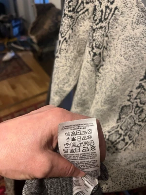 Vit ormönstrad klänning med trekvartsärm - Märkes klänning från Guess. Säljer en vit klänning med svart ormönster och trekvartsärm. Klänningen har en kroppsnära passform och är tillverkad i ett stretchigt material med inslag av elastan. Perfekt för dig som vill sticka ut med ett djurmönster.