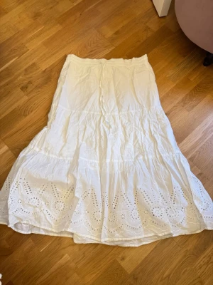 Vit långkjol med broderade detaljer - Säljer en vit långkjol med fina detaljer nertill! nästintill aldrig använd och i fint skick!🤍🤍
