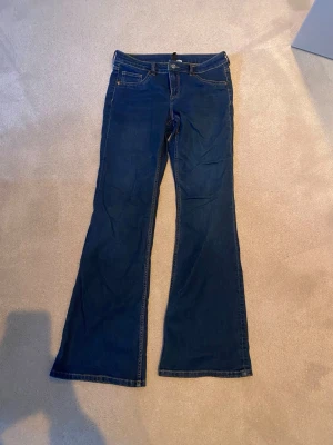 Mörkblå bootcut jeans från HM  - mörkblåa bolotcut jeans från HM i storlek 40. andvända få gånger 