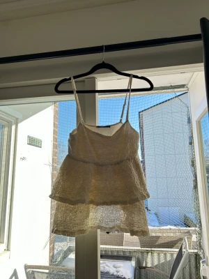 Ljusbeige volangig linnetopp -  söt ljusbeige linnetopp med tunna axelband och dubbla volanger. 