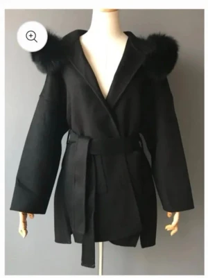 Svart kappa med fuskpäls och huva - En svart kappa med päls som knappt är använd. köpte den för 1800kr o har knappt använt den, säljer den för 1300kr men kan gå ner vid snabb affär. st 36 men passar även xs-m