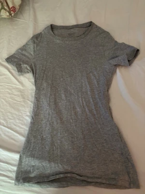 Grå t-shirt från intimissimi  - Enkel och stilren grå t-shirt topp med rund halsringning och korta ärmar. Tillverkad i mjukt bomullsmaterial som känns skönt mot huden. Perfekt att matcha med jeans eller kjol för en avslappnad look. Storlek S💗