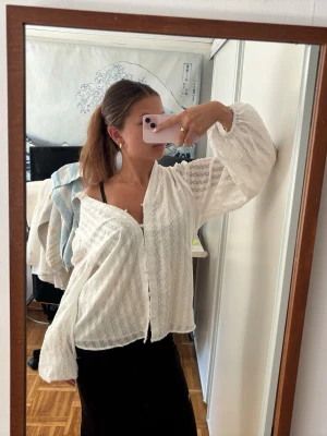 Vit transparent blus med knappar - Säljer en vit, luftig blus med transparent tyg och diskret mönster. Blusen har långa ärmar och knäppning framtill. Perfekt för dig som gillar en avslappnad men ändå chic stil. Passar till både jeans och kjol! Den är från Amisu ❤️