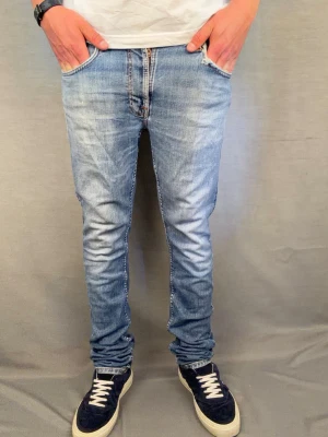 Nudie jeans lean dean  - Nudie jeans . Modell: lean dean. Size: 32 L34. Modell: lean dean. Midja 42cm längd 107cm. Modellen är 180cm. Skick 7/10 begagnat men bra skick. Hör av dig vid intresse 😄