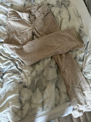 Beige byxor  från Nelly - Säljer ett par snygga beige byxor från Nelly i storlek 36. Byxorna har klassisk femficksmodell, raka ben och stängs med dubbla knappar och dragkedja. Perfekta för dig som gillar en avslappnad men trendig stil. Har samma i grön😃