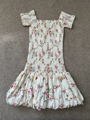 Populär klänning från h&m  - Klänning i smock från hm. Den är o olika färger och är blommig. Super fint skick. Andvänd ca 1-2 gånger. Storlek XS