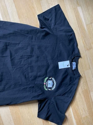 Svart t-shirt från Casablanca - Svart t-shirt från Casablanca med tryck av ett tempel och logga på bröstet. Klassisk passform med rund hals och korta ärmar. Materialet är mjuk bomull, perfekt för en avslappnad stil. Storlek L men passar M om man vill ha lite oversized. 