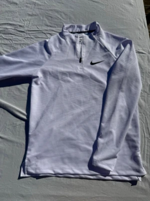 Vit långärmad träningströja Nike - Säljer denna vita träningströja från Nike då den sitter lite för tajt vid handlederna på mig. Fick den i present och har inte tränat i den. Tröjan är storlek M men skulle nog passa dig som vanlightvis bär Small. Tveka inte att skriva vid frågor eller för fler bilder//Felkannn