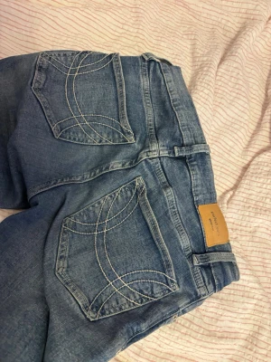 Gina tricot jeans - Low waist bootcut jeans från bikbok, de är i bra skick men är lite slitna längst ner på byxan som ses på bilden.