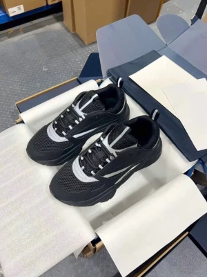 Svarta och vita sneakers med meshdetaljer - Snygga svarta sneakers med vita detaljer och meshpaneler för extra ventilation. Skorna har en chunky sula, svarta och vita snören samt dragflikar bak. Perfekta för dig som gillar sportig och modern stil.