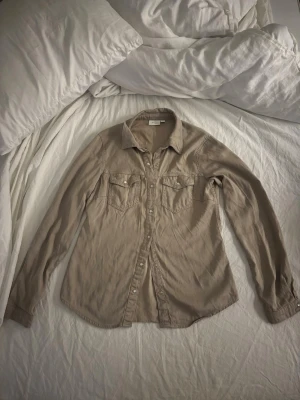 Beige skjorta från VILA - Beige skjorta från VILA med fickor framtil och ärmar med knapp vid ärmslut. Pris går att diskuteras!
