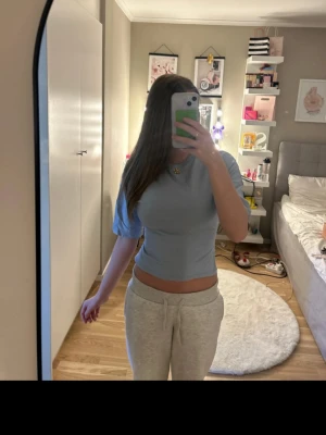 Ljusblå knyttopp - Trendig ljusblå croppad topp med korta ärmar och öppen rygg som knyts baktill. Perfekt för dig som vill ha en unik detalj på din outfit. Snygg passform och mjukt material som känns skönt mot huden.