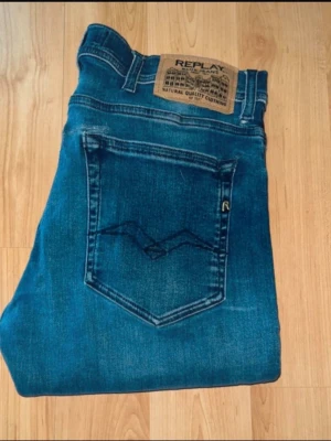 Replay jeans  - Blå Replay Jondrill jeans. Midja 38cm, längd 100cm. OBS jeansen har flertal defekter: Hål vid skrevet som sluts igen med trådar så länge det inte töjs ut. Hål längst upp vid ena öggland baktill. Samt hål vid bakfickorna som har sytts igen med lappar. OBS längdmåttet saknas, jag bedömer jeansen till L32 - MEN utgå efter måtten. JAG SKICKAR EJ FLER BILDER NÄR JAG BÄR JEANSEN! Storleksguide kolla måtten noggrant då jeansen alltid kan vara uppsydda heller krympta och jag ej tar emot returer:) 1,15