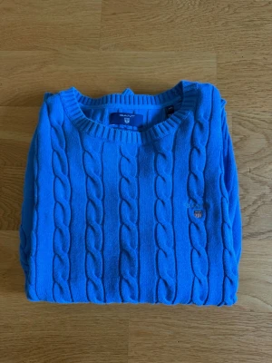 Blå kabelstickad tröja från Gant - Snygg blå kabelstickad tröja från Gant. Storleken är XS, men sitter som S. Tröjan är i bra skick. Hör av er vid frågor!😀