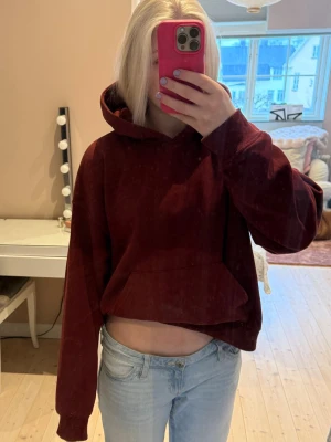 Vinröd Gina Tricot hoodie - Säljer en vinröd mysig hoodie med huva och magficka från Gina Tricot. Hoodien har en avslappnad passform och långa ärmar. Perfekt för dig som gillar en chill och enkel stil. Materialet känns mjukt och skönt mot huden. Bra skick och så skön 