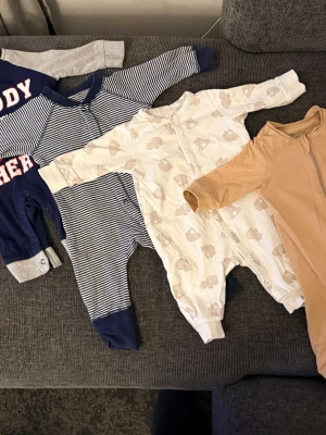Mix av babypyjamas i olika färger - Fyra olika babypyjamas i mjuka material. Använda av ett barn inte alls mycket. 