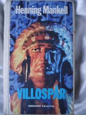 Villospår av Henning Mankell - Kriminalroman av Henning Mankell med titeln Villospår. Inbunden med ljus rygg och svart text. Perfekt för dig som gillar spännande deckare. Köpt från ett bibliotek och är ganska använd.
