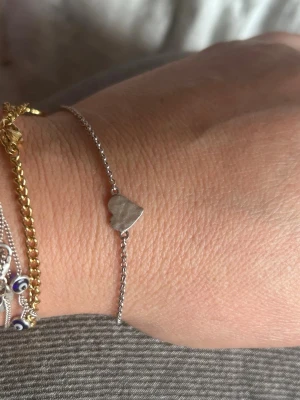 Armband Sophie by Sophie med pärlor - Snyggt armband från Sophie by Sophie i silver med små blå och vita pärlor. Armbandet har en tunn kedja och detaljer med ögonpärlor som ger en cool och trendig look. Perfekt accessoar för att lyfta din outfit.