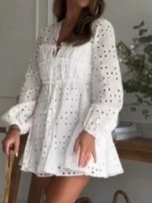  Ny Vit broderad kortklänning från Zara - Söt vit kortklänning från Zara med broderade detaljer och hålmönster. Klänningen har v-ringning, långärmade ärmar med resår vid handlederna och en liten knytning framtill. Perfekt för sommarens alla tillfällen.